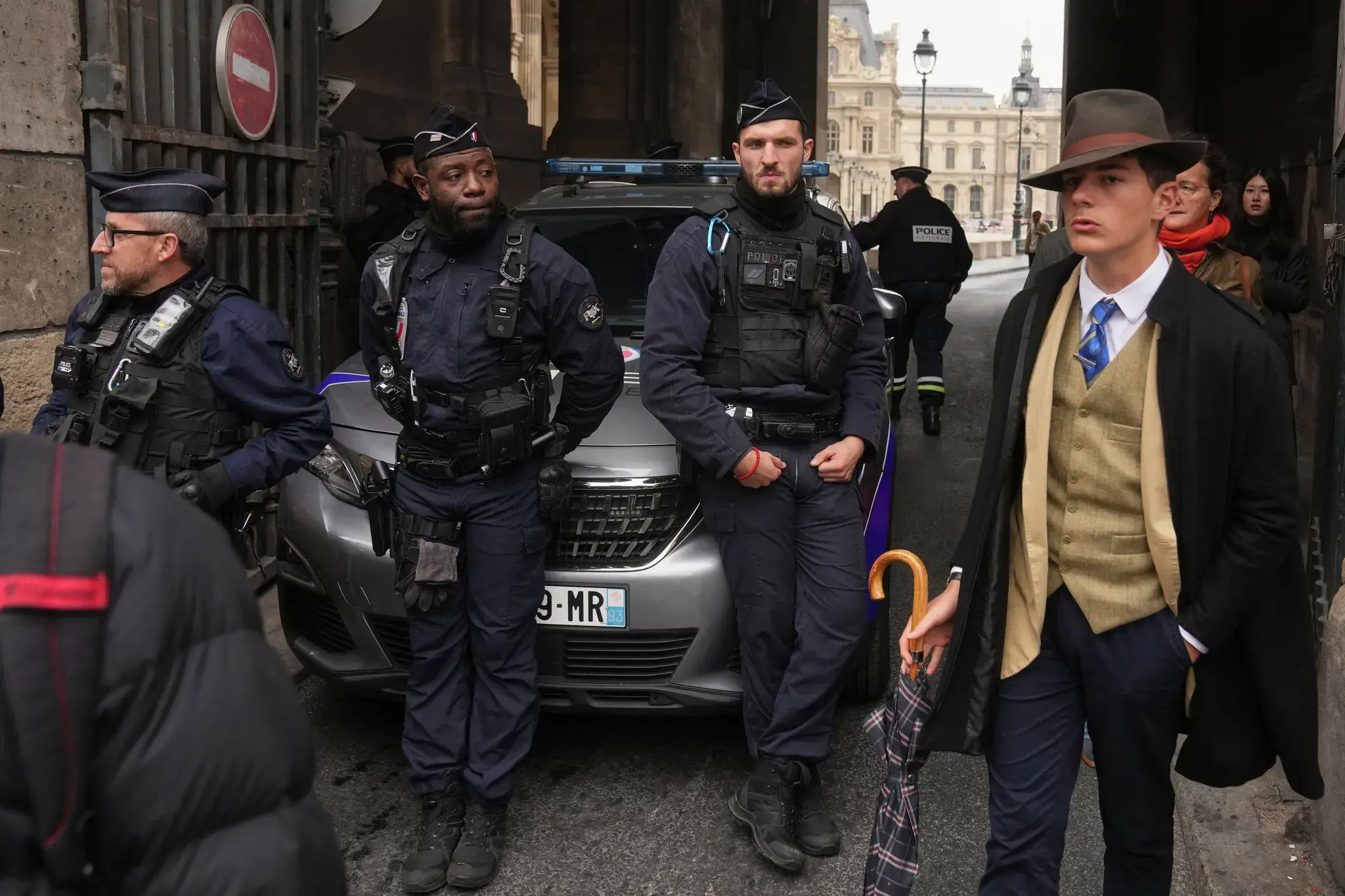 In a scene that confused many people on social media, a sharply-dressed man walked near police officers blocking an entrance at the Louvre on Sunday.